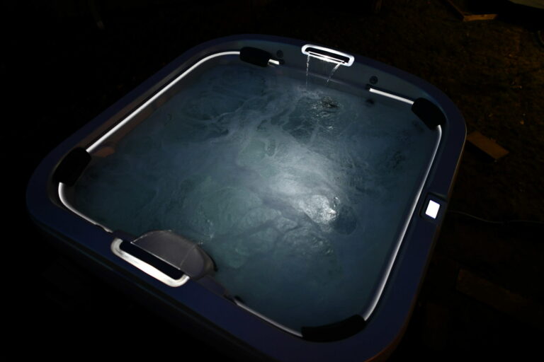 Outdoor hot tub with LED illumination at night - why your hot tub is worth the wait