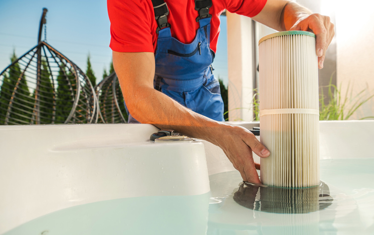hot tub maintenance - hot tub service technician replacing spa filter